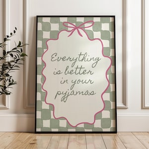 Może przedstawiać: Oprawiona grafika ścienna z napisem "Everything is better in your pyjamas". Grafika przedstawia r&oacute;żową kokardę i falisty brzeg. Tło ma zielono-biały wz&oacute;r w kratę.