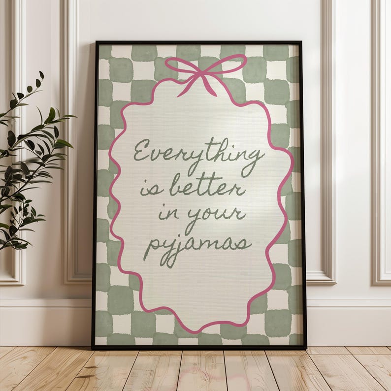 Może przedstawiać: Oprawiona grafika ścienna z napisem "Everything is better in your pyjamas". Grafika przedstawia r&oacute;żową kokardę i falisty brzeg. Tło ma zielono-biały wz&oacute;r w kratę.