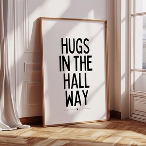 May include: A black and white printable wall art print with the text "HUGS IN THE HALL WAY" in a bold font.
