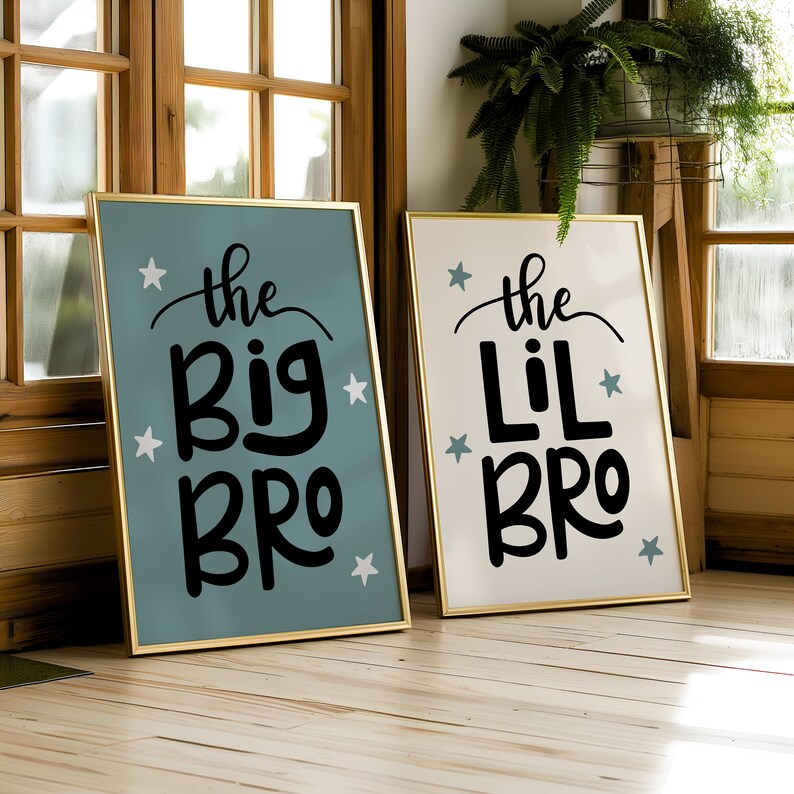 May include: Two gold framed signs with blue and white stars. The sign on the left says "the big bro" in black script. The sign on the right says "the lil bro" in black script.