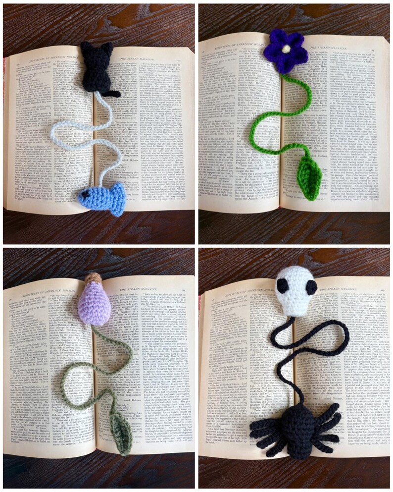 May include: Four handmade crochet bookmarks in an open book. The bookmarks feature a black cat with a blue fish, a purple flower with a green leaf, a lavender bulb with a green leaf, and a white skull with a black spider.