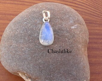 May include: A teardrop-shaped moonstone pendant with a silver setting. The stone is iridescent and has a blue-white color.