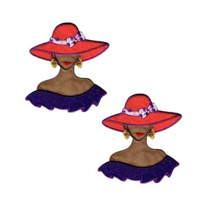 May include: Two identical embroidered patches featuring a figure with brown skin wearing a wide-brimmed red hat with a white and purple patterned bow, gold hoop earrings, red lipstick, and a dark purple ruffled off-the-shoulder garment.