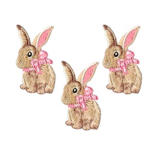 May include: Three brown embroidered bunny rabbit patches with pink bows. The bunnies are sitting upright with their ears perked up.
