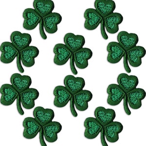以下が含まれることがあります： 刺繍のディテールが施された緑色のクローバーのパッチが10枚。クローバーはすべて同じサイズと形であり、対称的なパターンで配置されています。