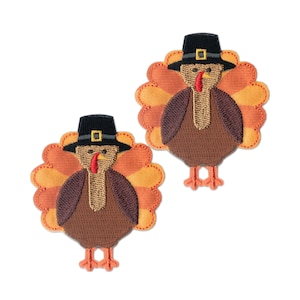 May include: Two embroidered iron-on patches of turkeys wearing pilgrim hats. The turkeys are brown with orange and yellow feathers. The hats are black with a gold buckle.
