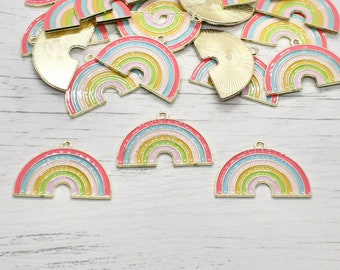 May include: A group of gold-tone rainbow charms with pink, yellow, green, and blue enamel. The charms are shaped like rainbows and have a hole at the top for attaching to a necklace or bracelet.