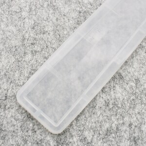 May include: A clear plastic comb with a textured surface. The comb is designed for detangling hair.