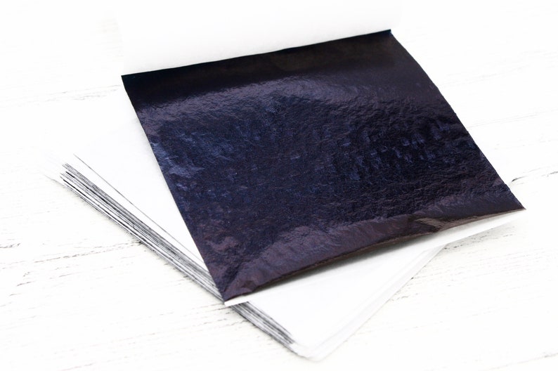 May include: A stack of thin, metallic sheets in a dark blue colour. The sheets are slightly wrinkled and have a subtle sheen.