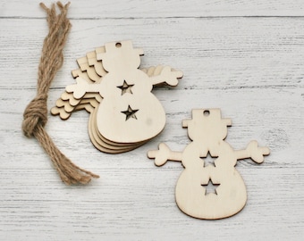 Könnte beinhalten: Ein Satz aus Holzschneemann-Anhängern mit einem Stern-Ausschnitt-Design. Die Anhänger sind unbemalt und können bemalt oder verziert werden.
