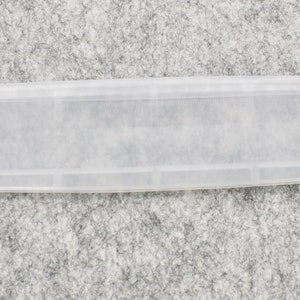 May include: A clear plastic storage case with multiple compartments. The case is designed to hold small items, such as jewelry, craft supplies, or medication.