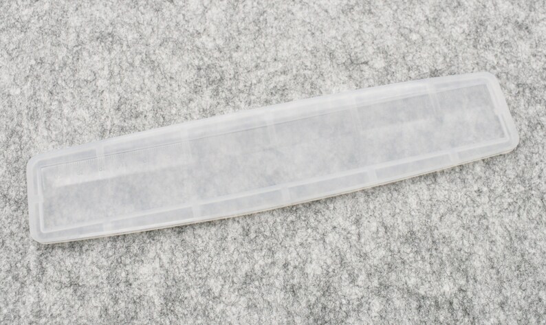 May include: A clear plastic tray with multiple compartments. The tray is designed to hold small items, such as jewelry or craft supplies.