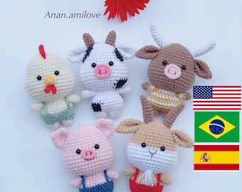 May include: Five crocheted animal plushies: a brown cow, a brown bull, a white chicken, a pink pig, and a brown goat. Each plush is wearing overalls. The plushies are arranged on a white surface. The text "Anan.amilove" is visible in the top left corner of the image.