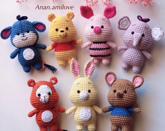 May include: A collection of seven crocheted stuffed animals, including Winnie the Pooh, Piglet, Eeyore, Tigger, and Rabbit. The animals are all different colors and have different facial expressions.