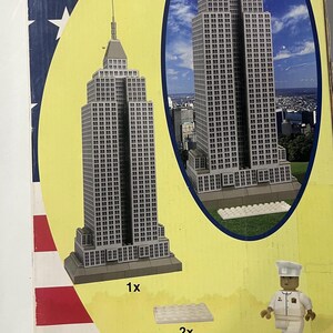 May include: A Best-Lock construction toy box featuring a model of the Empire State Building. The box includes images of the completed model, a police officer figure, and the text "437 PIECES". The box also displays the Best-Lock logo and the text "Build a Lot... Pay a Little!"