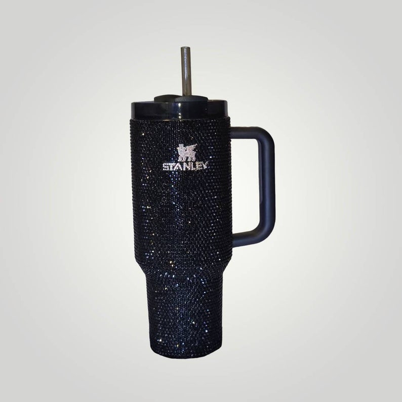 Puede incluir: Taza de viaje Stanley negra con asa negra y tapa negra. La taza est&aacute; cubierta de diamantes de imitaci&oacute;n y tiene el logotipo de Stanley en la parte delantera.