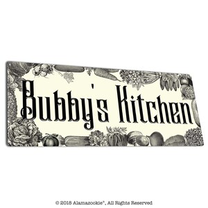May include: Rectangular kitchen sign with the text "Bubby's Kitchen" in black, surrounded by a border of black and white illustrations of various vegetables. The background is off-white.