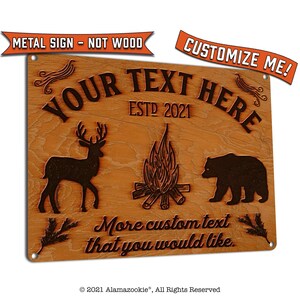 May include: A brown metal sign with a wood grain texture. The sign features a deer, a campfire, and a bear. The text on the sign reads "YOUR TEXT HERE ESTD 2021 More custom text that you would like."