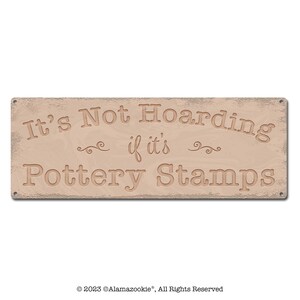 May include: A rustic wooden sign with the text "It's Not Hoarding if it's Pottery Stamps". The sign has a distressed, weathered look and is painted in a light brown color.