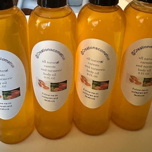 May include: Four clear plastic bottles filled with golden-yellow body oil, each featuring a white oval label. The text reads: @Creationscometrue, all natural carrots and turmeric body oil, 8 FL OZ, Follow me on instagram and facebook.