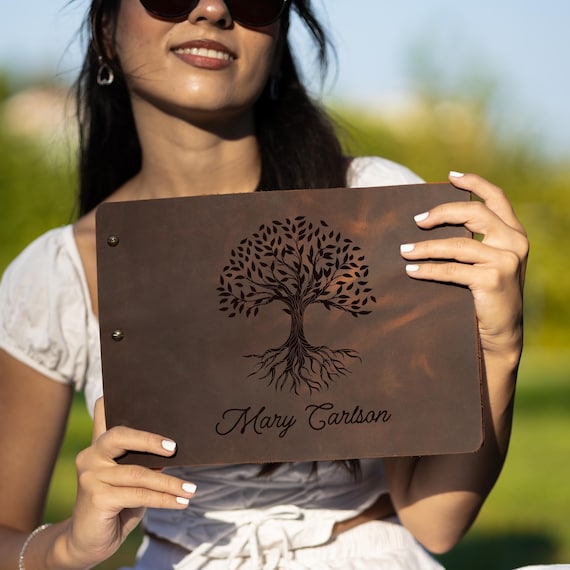 Full-grain leather memory journal with a Tree of Life motif — genuinely tactile, heirloom-quality craft that's meant to be passed down.