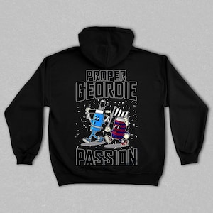 以下が含まれることがあります： 黒色のパーカー。白文字で「PROPER GEORDIE PASSION」と書かれています。背面には、旗を持った2人の漫画のキャラクターのイラストが描かれており、1人は青色、もう1人は赤と青色です。