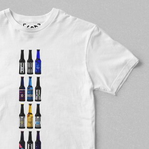 May include: White t-shirt with a vertical row of 12 colorful beer bottles printed on the front. The bottles have different labels with various designs and text.