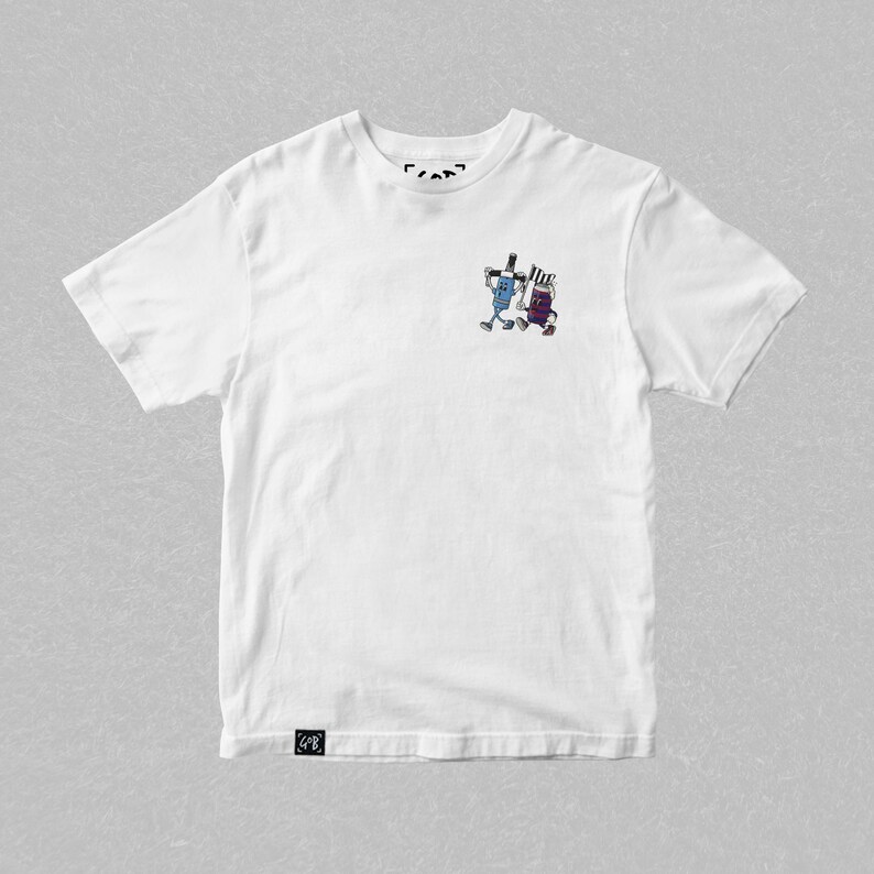 May include: White t-shirt featuring a small graphic of two cartoon characters with arms and legs. One character is blue and the other is purple. The shirt has a crew neck and short sleeves. The brand logo is at the top and bottom of the shirt.