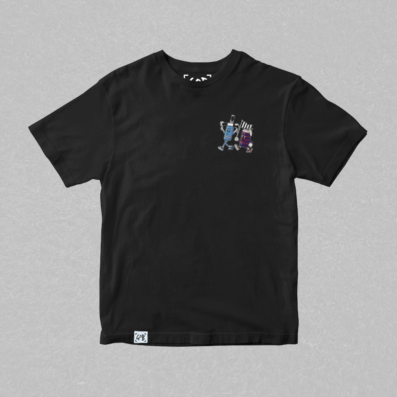 May include: Black t-shirt with a small, colorful graphic of two cartoon figures. One figure is blue and the other is purple. The shirt has a crew neck and short sleeves. The brand logo is visible at the top and bottom of the shirt.