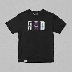 K&ouml;nnte beinhalten: Schwarzes T-Shirt mit einem Aufdruck von drei Aluminiumdosen. Jede Dose zeigt das Trikotdesign eines anderen Fu&szlig;ballteams. Der Text "Basela" ist auf jeder Dose aufgedruckt.