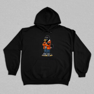 Puede incluir: Sudadera con capucha negra con un personaje de cuervo de dibujos animados que lleva gafas de sol, una gorra negra, una chaqueta naranja, vaqueros azules y zapatillas deportivas. El cuervo tiene los brazos cruzados. La sudadera tiene un bolsillo delantero.