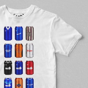 May include: White t-shirt featuring a graphic of various beverage cans with team jersey designs. The cans are in blue, orange, red, and black, with text such as "FISONS" and "GREENE KING".