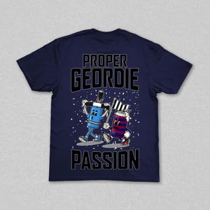 May include: Navy blue t-shirt with the words "PROPER GEORDIE PASSION" in black block letters. The shirt features cartoon illustrations of a blue marker and a red and blue can, each holding a flag.