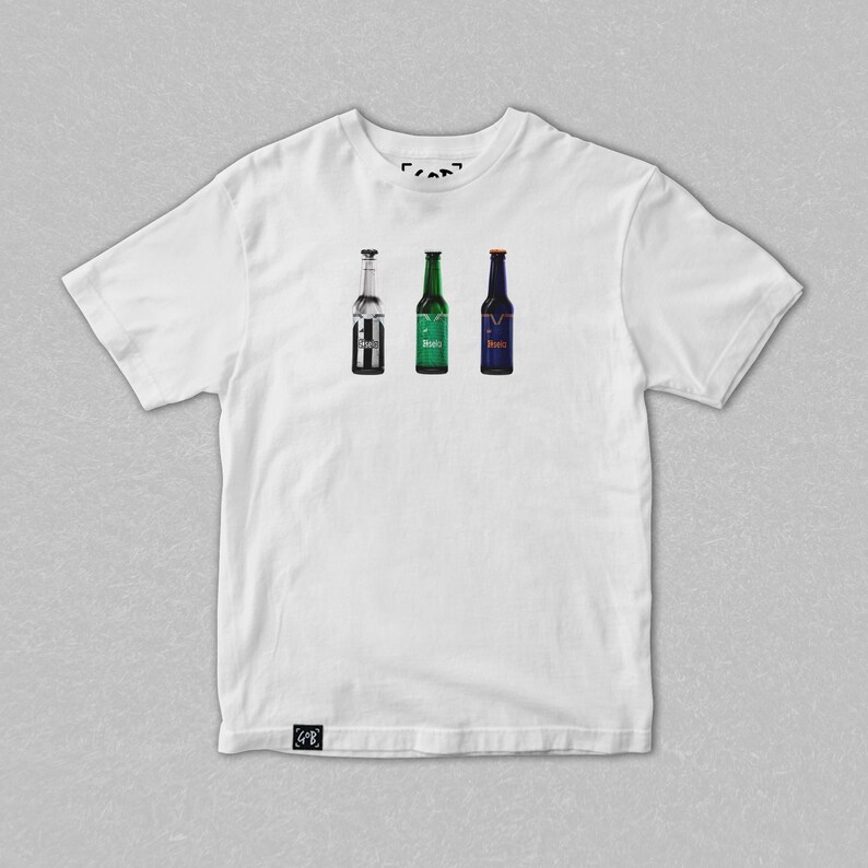 May include: White t-shirt featuring three beer bottle illustrations. The bottles are in silver, green, and blue, each with a different label. The shirt has a crew neck and short sleeves. The shirt is made of a soft, comfortable material.