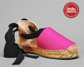 Charm espadrilles for girls, fuxia pink and black bows, sewn by hand in La Rioja, Spain | Easy to tie to the ankle