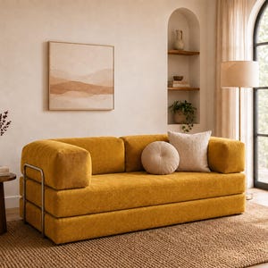 May include: A mustard yellow corduroy sofa featuring a low-profile design with thick, rectangular cushions and a metallic frame on the left side. The sofa is accented with one round beige pillow and one square textured off-white throw pillow.