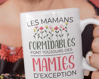 May include: White ceramic mug with a black and pink design. The mug reads "Les mamans formidables font toujours des mamies d'exception".