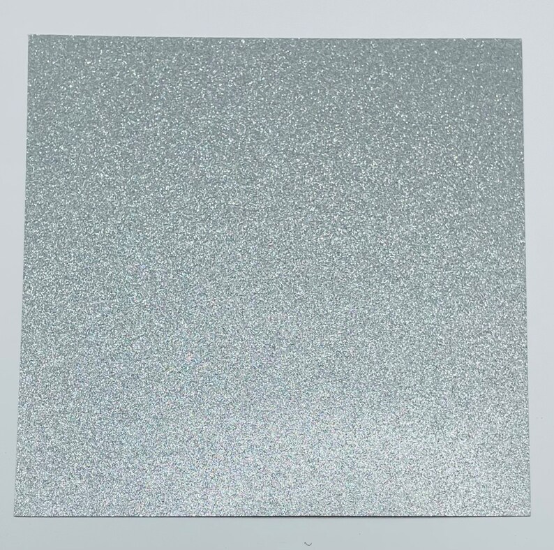 May include: A sheet of silver glitter paper. The paper has a fine, even glitter texture.