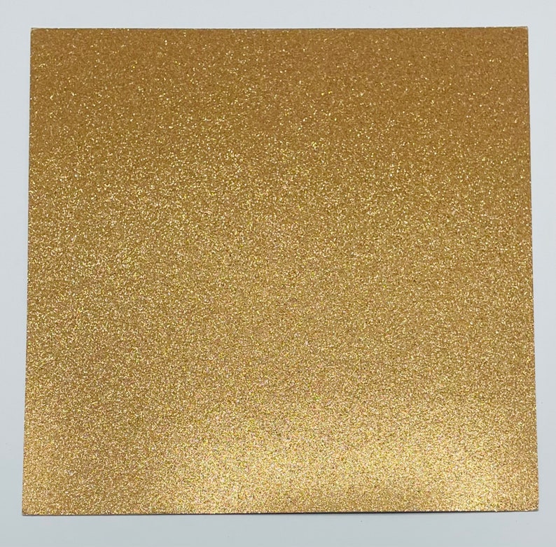May include: A sheet of gold glitter paper. The paper has a fine, even glitter texture.