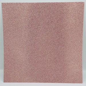 May include: A sheet of rose gold glitter paper. The paper has a fine, even glitter texture.