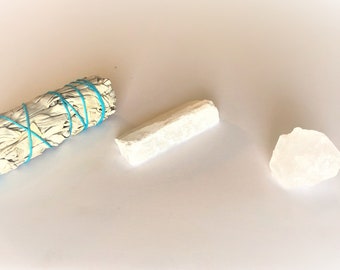 Può includere: Un bastoncino di salvia bianca legato con uno spago turchese, un cristallo di selenite bianco e una lastra di selenite bianca.