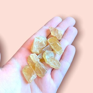 May include: A handful of small, translucent, yellow-gold crystals. The crystals are irregularly shaped and have a slightly rough texture.