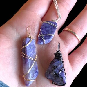 May include: Three wire-wrapped pendants featuring purple and blue stones. The pendants are made with gold and silver wire. The stones are wrapped in a variety of patterns.