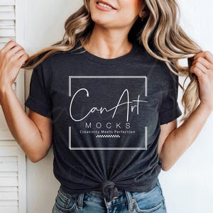 May include: A woman wearing a dark gray t-shirt with a white graphic that says "CanArt MOCKs Creativity Meets Perfection".