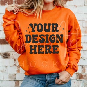 Könnte beinhalten: Orangefarbener Pullover mit dem Text "YOUR DESIGN HERE" in Schwarz.