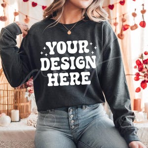 May include: A dark gray sweatshirt with long sleeves and a white graphic that says "YOUR DESIGN HERE" with stars on either side of the text.