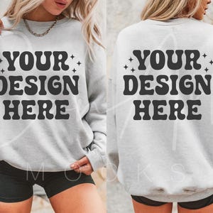 Puede incluir: Una sudadera gris con el texto "YOUR DESIGN HERE" impreso en la parte delantera y trasera. La sudadera está siendo modelada por una persona que lleva pantalones cortos negros.