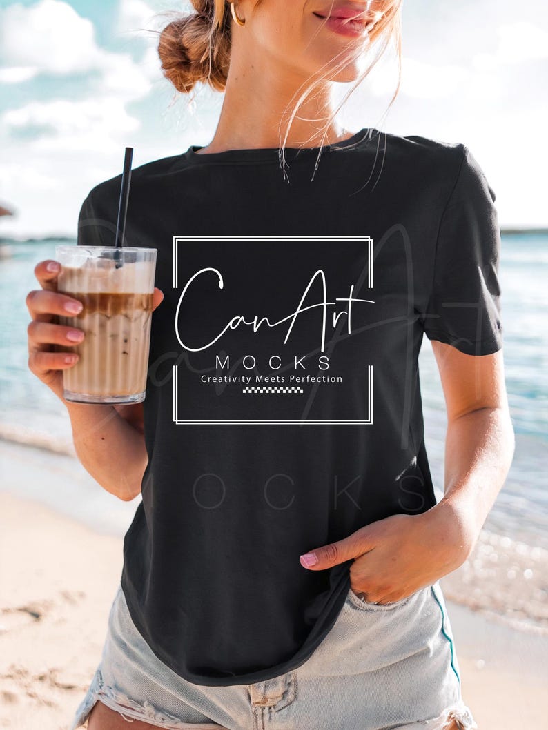 May include: A black t-shirt with a white graphic that says "Can Art Mocks" and "Creativity Meets Perfection". The shirt is being worn by a person on a beach.