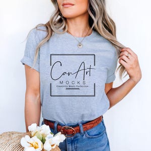 Pode incluir: Uma camiseta cinza com um gr&aacute;fico preto que diz "CanArt MOCKS Creativity Meets Perfection".