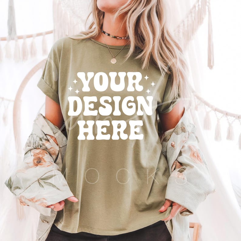 May include: A green t-shirt with the text "YOUR DESIGN HERE" in white. The shirt is being modeled by a person with long blonde hair.